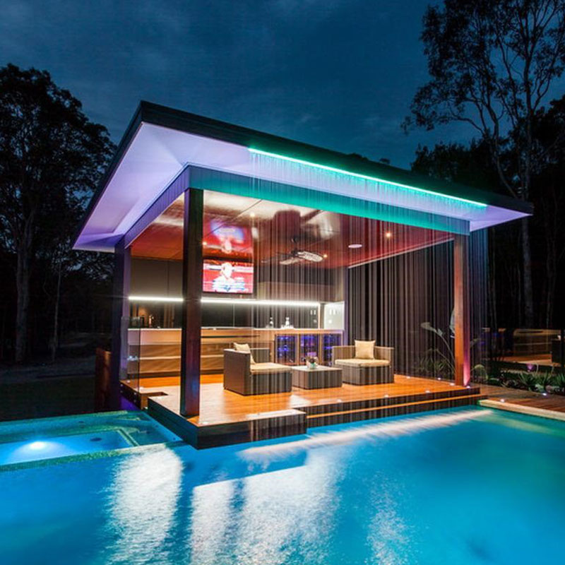 Illuminated pool and garden lounge area at night