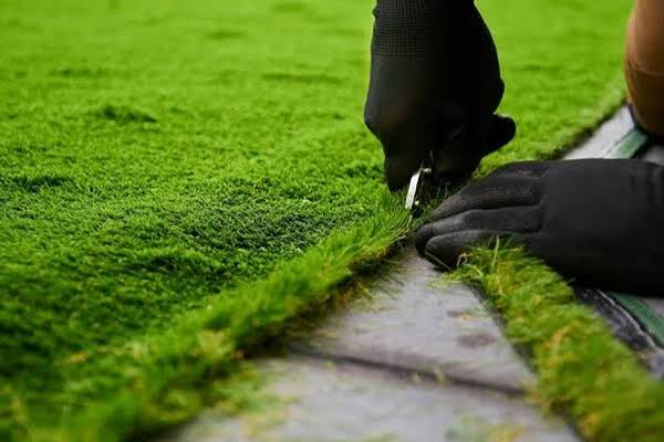 Artificial grass being cut and installed at a Dubai villa